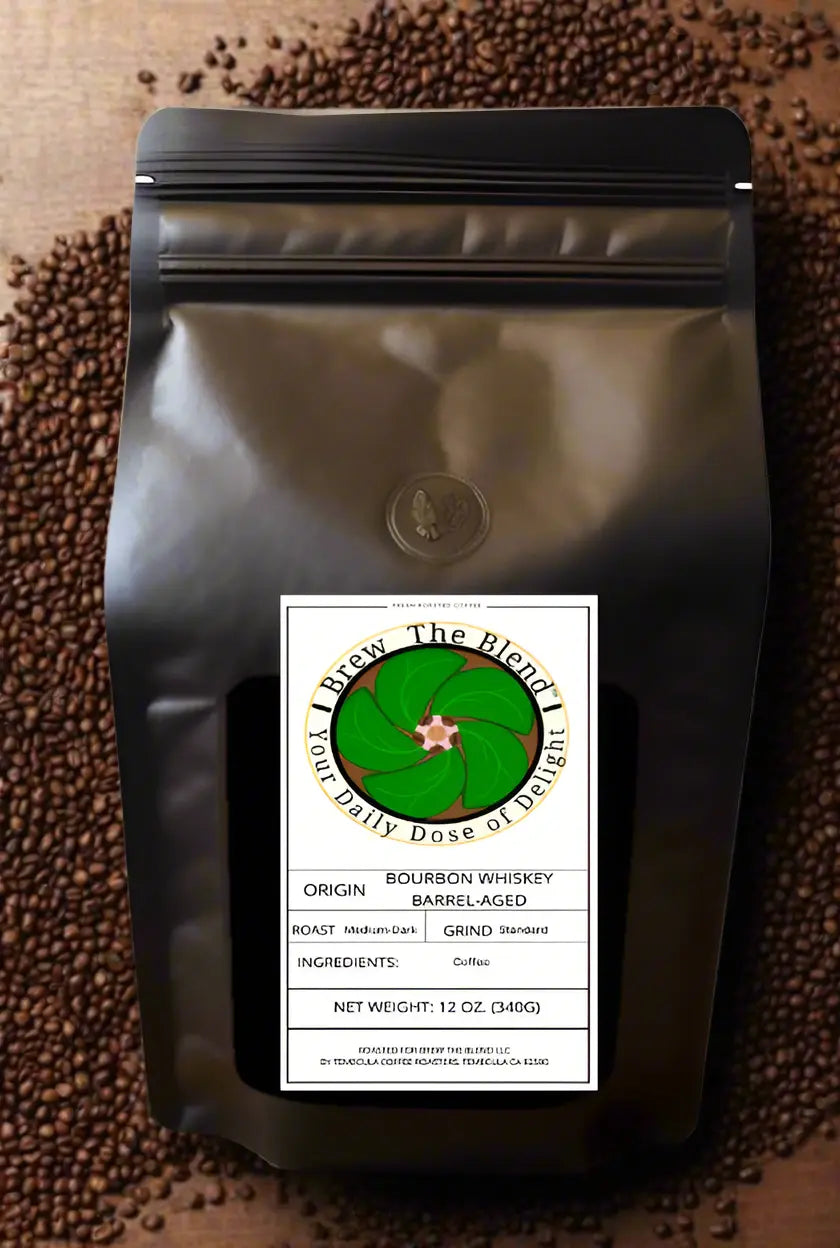 A black resealable stand-up pouch of coffee beans with a white front label reading 'The Blend' and 'Bourbon Whiskey Barrel-Aged,' photographed on a surface covered with brown coffee beans.