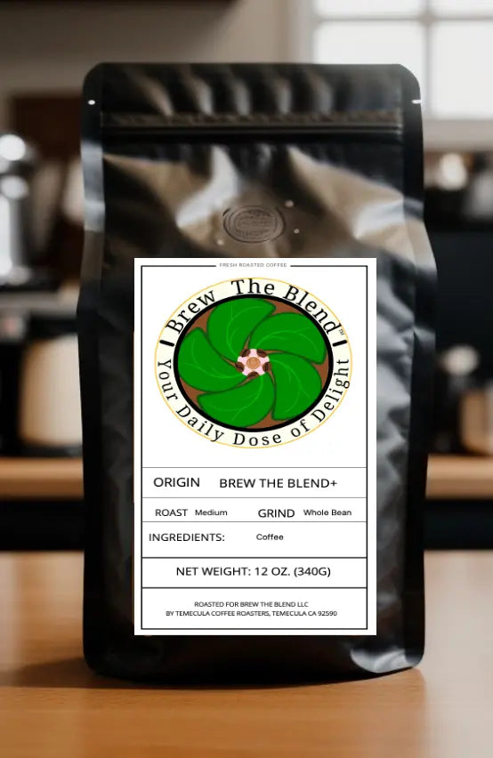A black coffee bag labeled 'Brew The Blend+' stands on a wooden surface with a blurred kitchen background. The front label features a green coffee bean illustration and text detailing the coffee blend's origin, roast, grind, and net weight.