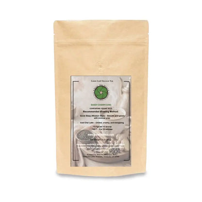 A stand-up kraft paper pouch of Sassy Charm Chai with a central white and green label, photographed on a clean white background. 