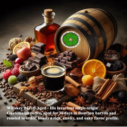 A styled still life of a whiskey barrel-aged coffee setup with a glass of dark coffee, chocolate pieces, spices, citrus slices, berries, and coffee beans around a bottle and barrel. Text at the bottom reads: 'Whiskey Barrel-Aged - His luxurious single-origin Guatemala coffee, aged for 30 days in Bourbon barrels and roasted to order, boasts a rich, smoky, and oaky flavor profile.